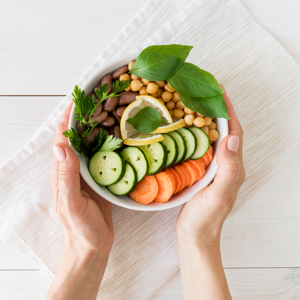 hands holding a bowl of fresh vegetables