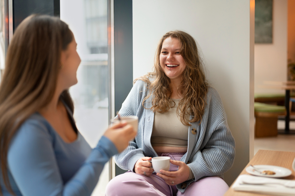 two women smiling and having tea
