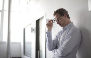 thoughtful man leaning on wall