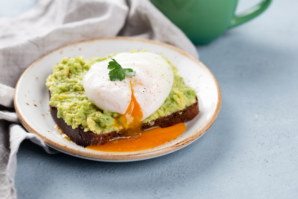 Toast topped with avocado and poached egg