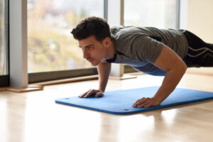 Man holding plank position indoors