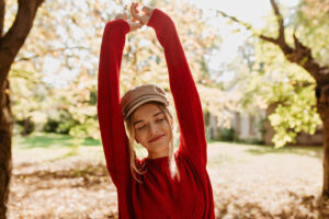 Smiling woman stretching arms in the morning