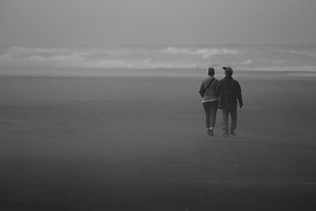 couple walking on beach seen from afar